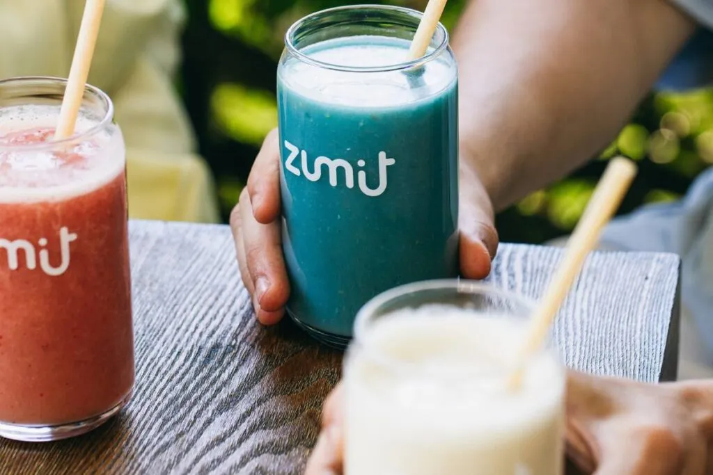 Smoothies para Horeca Zumit Blue Lightning con mango, plátano, piña, melocotón, coco y espirulina azul sobre una mesa