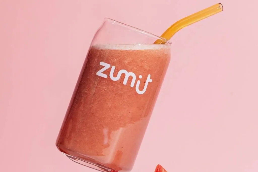 Smoothie Zumit Vitality con fresa y plátano sobre un fodo rosa