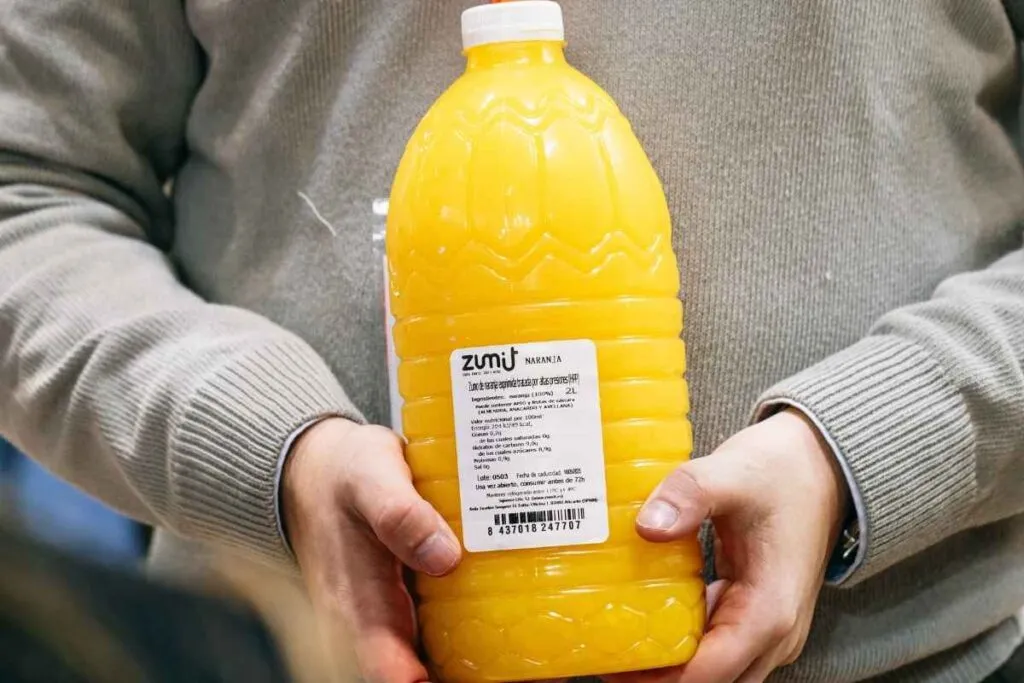 zumo de naranja envasado Zumit en unas manos